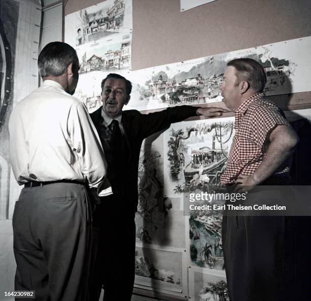 Walt Disney stands by a plan of Disneyland and chats with some imagineers circa 1954 in Los Angeles, California.