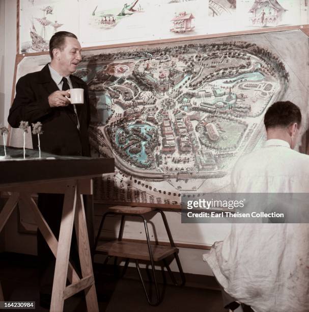 Walt Disney stands by a plan of Disneyland and chats with an imagineer circa 1954 in Los Angeles, California.