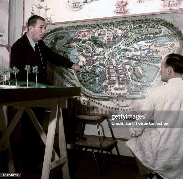 Walt Disney stands by a plan of Disneyland and chats with an imagineer circa 1954 in Los Angeles, California.