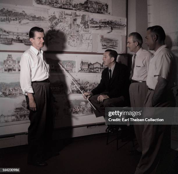 Walt Disney stands by a plan of Disneyland and chats with some imagineers circa 1954 in Los Angeles, California.