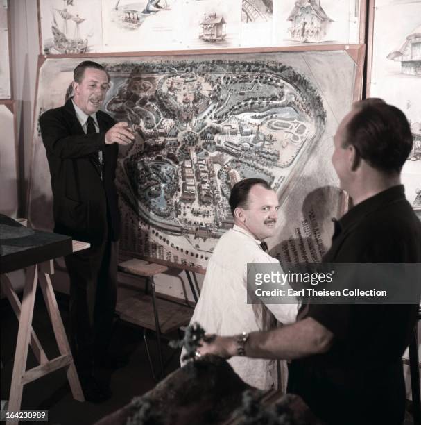 Walt Disney stands by a plan of Disneyland and chats with some imagineers circa 1954 in Los Angeles, California.