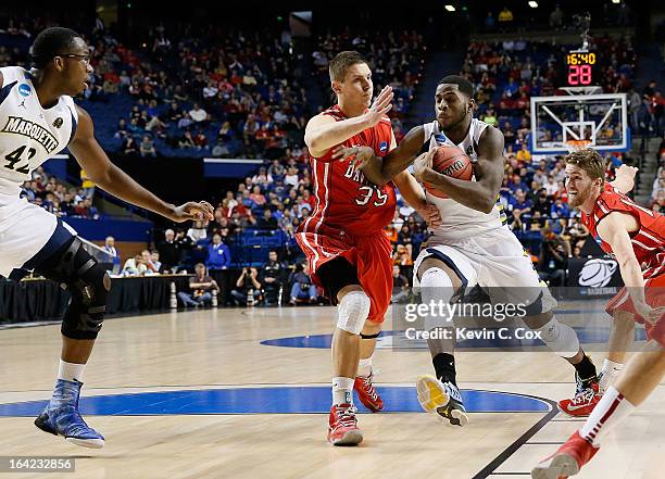 Jamil Wilson of the Marquette Golden Eagles drives against Chris Czerapowicz of the Davidson Wildcats in the first half during the second round of...