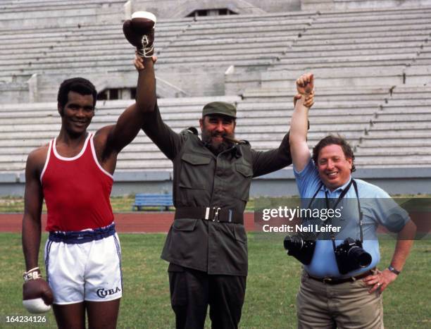 Summer Games Preview: Portrait of Cuban President Fidel Castro with heavyweight boxer Teofilo Stevenson and TIME Magazine photographer Neil Leifer...