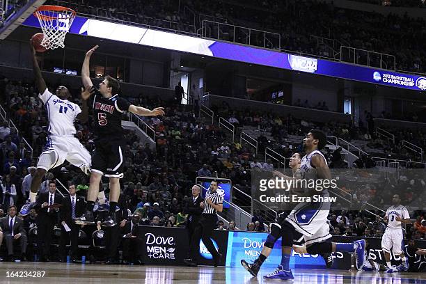 Mike McCall Jr. #11 of the Saint Louis Billikens goes up against Kevin Aronis of the New Mexico State Aggies in the second half during the second...