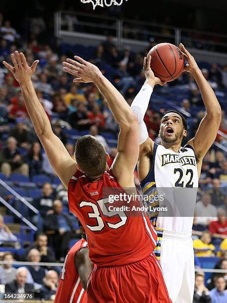 Trent Lockett of the Marquette Golden Eagles shoots against Chris Czerapowicz of the Davidson Wildcats in the second half during the second round of...