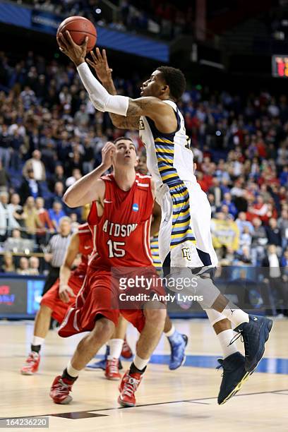 Vander Blue of the Marquette Golden Eagles scores the game-winning basket against Jake Cohen of the Davidson Wildcats to put Marquette ahead 59-58...
