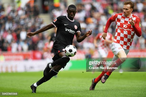 Randal Kolo Muani of Eintracht Frankfurt is challenged by Sepp van den Berg of 1.FSV Mainz 05 during the Bundesliga match between 1. FSV Mainz 05 and...