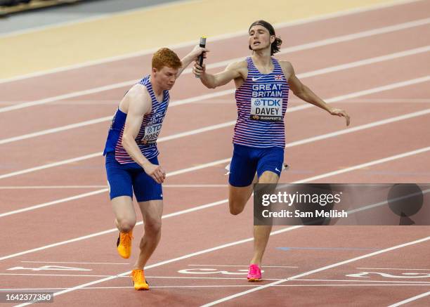 Lewis Davey pases the baton to Charles Dobson of Team Great Britain in the men's 4*400m Relay semi final during day eight of the World Athletics...