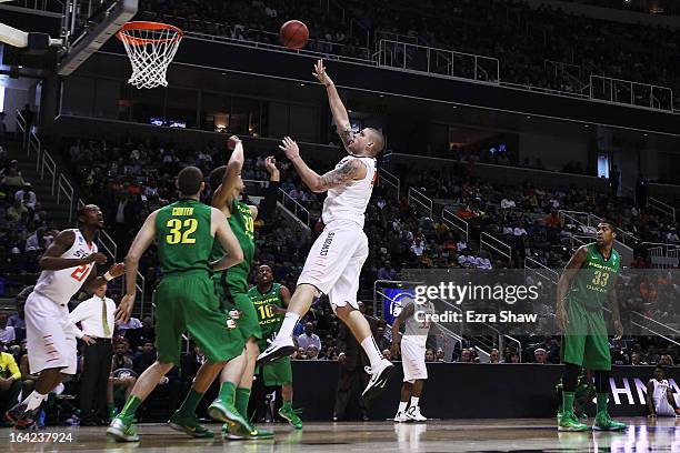 Philip Jurick of the Oklahoma State Cowboys shoots over Waverly Austin of the Oregon Ducks in the first half during the second round of the 2013 NCAA...