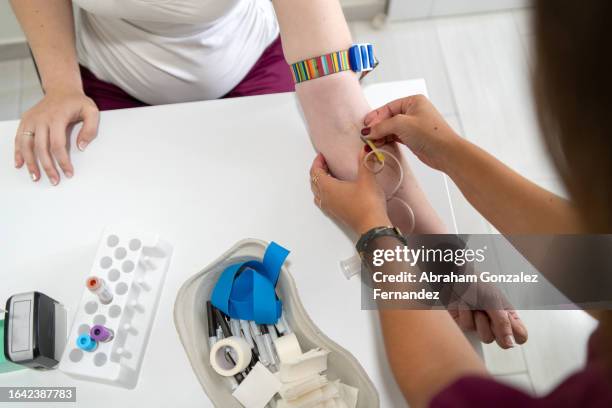 woman is going to donate blood in blood bank - groupe sanguin photos et images de collection