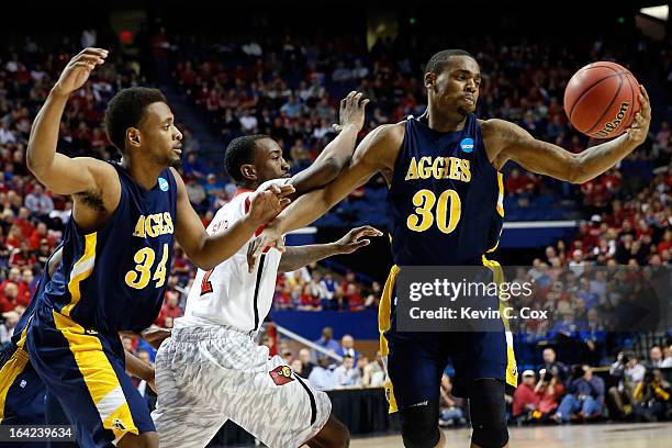 Lamont Middleton of the North Carolina A&T Aggies grabs the loose ball after it was knocked away from Russ Smith of the Louisville Cardinals by Bruce...