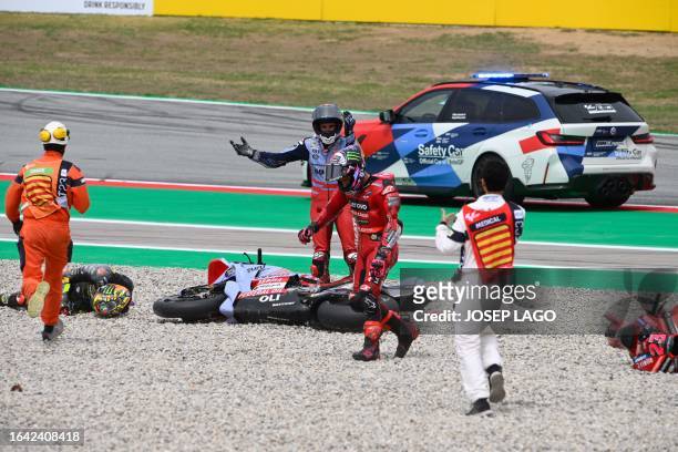 Riders react and receive assistance after a fall during the MotoGP race of the Moto Grand Prix de Catalunya at the Circuit de Catalunya in Montmelo,...