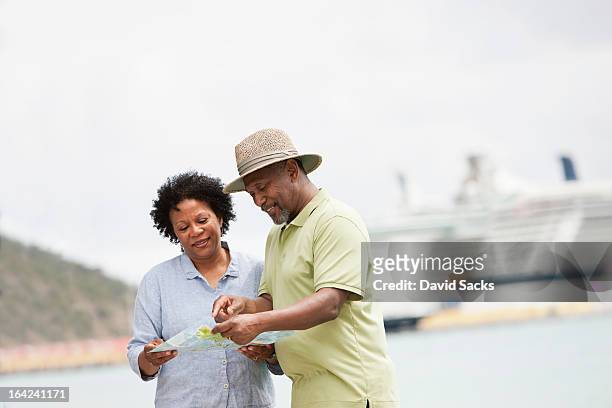 couple looking at a map - sint maarten foto e immagini stock