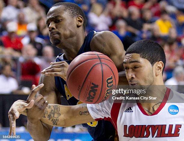 North Carolina A&T's Lamont Middleton, left, has the ball knocked out of his hands by Louisville's Peyton Siva in the first half in the NCAA...