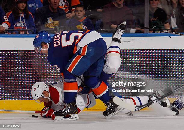 Andrei Markov of the Montreal Canadiens is tripped up by Casey Cizikas of the New York Islanders at the Nassau Veterans Memorial Coliseum on March...