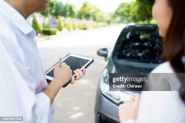 insurance claim agent inspecting an accident vehicle. - car accident report stock pictures, royalty-free photos & images