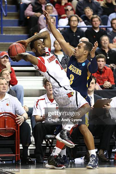Russ Smith of the Louisville Cardinals looks to pass the ball against Jeremy Underwood of the North Carolina A&T Aggies during the second round of...