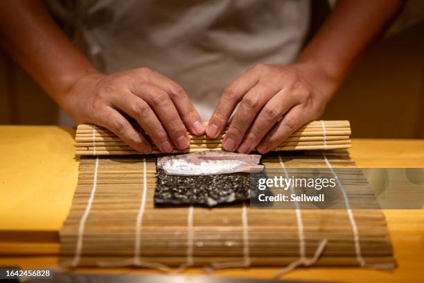 close up of chef preparing maki sushi - maki sushi stockfoto's en -beelden