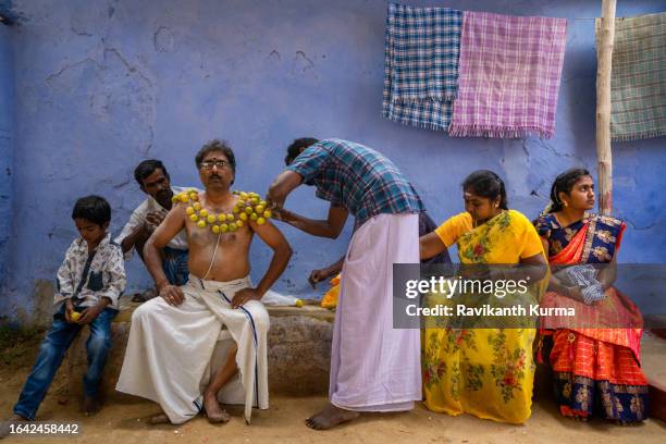 a devotee getting lemons stitched to his body with his family sitting around him. - kaveripattinam stock pictures, royalty-free photos & images
