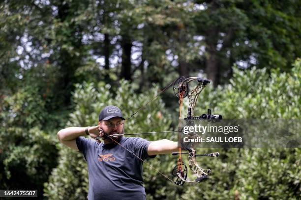 Taylor Chamberlin, an urban deer hunter with the goal of dealing with overpopulation in urban areas, practices with his bow in the backyard of his...