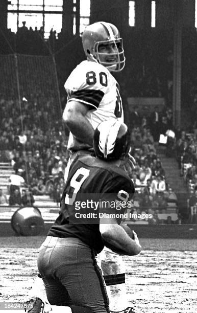 Defensive end Bill Glass of the Cleveland Browns smiles as he stands over quarterback Sonny Jurgenson of the Washington Redskins during a game on...