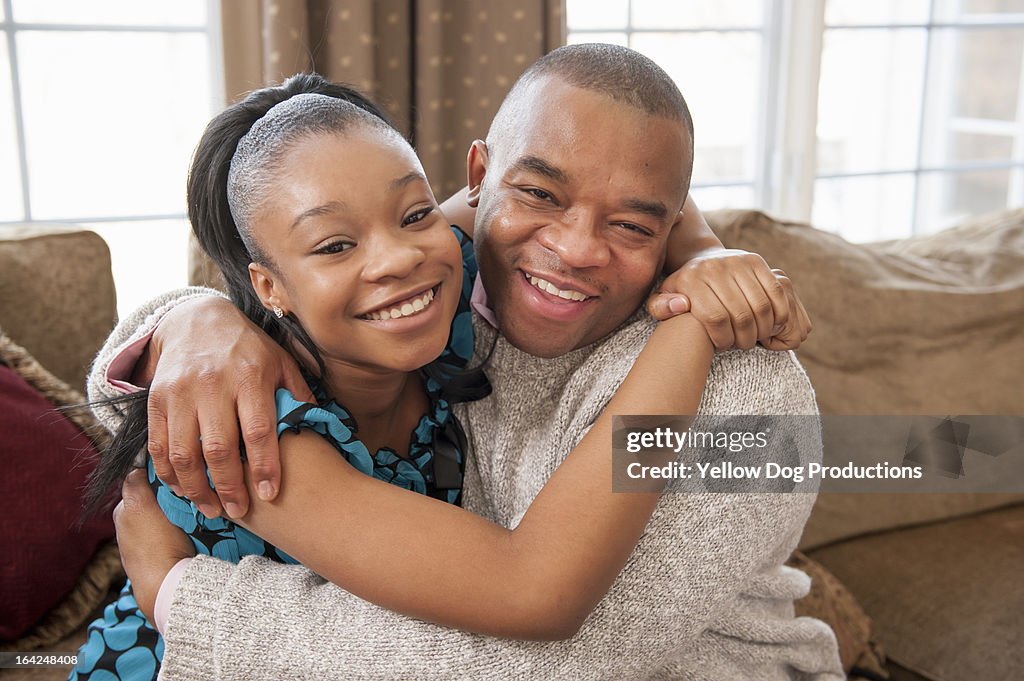 Father and his teen daughter hugging and laughing