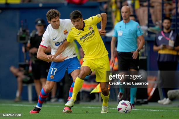 Marcos Alonso of FC Barcelona challenges for the ball with Gerard Moreno of Villarreal during the LaLiga EA Sports match between Villarreal CF and FC...