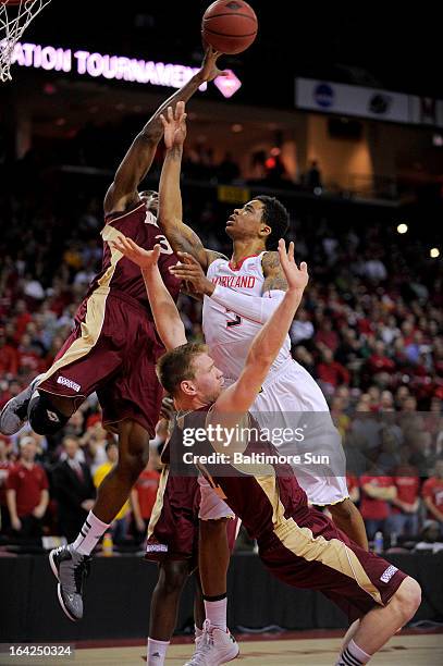 Maryland's Nick Faust cannot get his shot past Denver defenders Chris Udofia and Chase Hallam during first-half action in the NIT basketball...