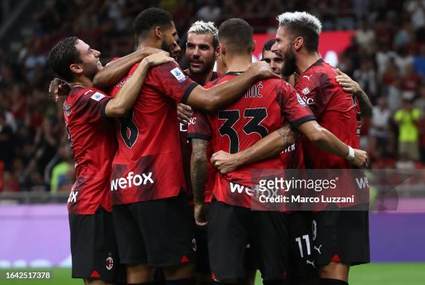 Olivier Giroud of AC Milan celebrates with his team-mates after scoring the team's fourth goal from a penalty kick during the Serie A TIM match...