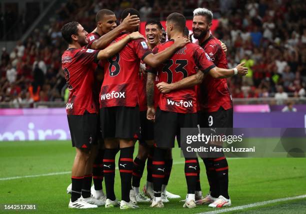 Olivier Giroud of AC Milan celebrates with his team-mates after scoring the team's fourth goal from a penalty kick during the Serie A TIM match...