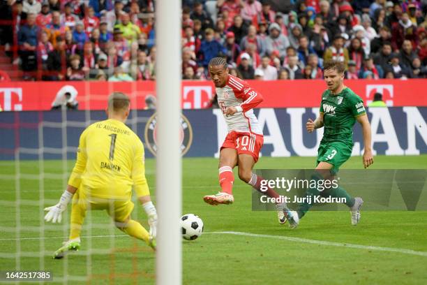 Leroy Sane of Bayern Munich takes a shot on goal ahead of Mads Pedersen of FC Augsburg during the Bundesliga match between FC Bayern München and FC...