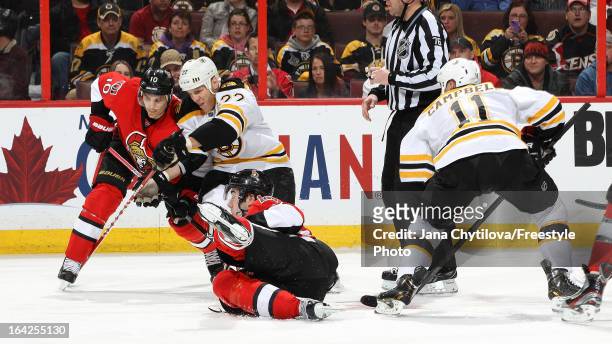 Mika Zibanejad of the Ottawa Senators falls to the ice as he wins the faceoff against Gregory Campbell of the Boston Bruins and Mike Lundin of the...