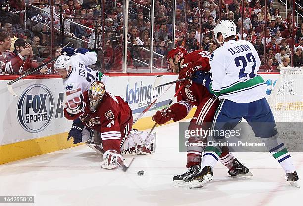 Goaltender Mike Smith of the Phoenix Coyotes is hit from behind from Alexander Edler of the Vancouver Canucks during the second period of the NHL...