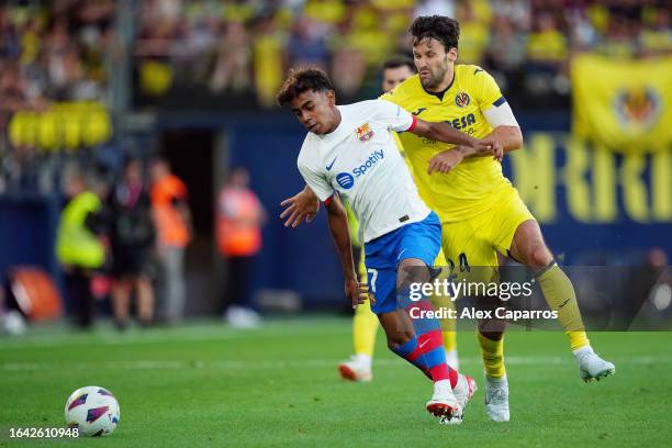 Lamine Yamal challenges for the ball with with Alfonso Pedraza of Villarreal during the LaLiga EA Sports match between Villarreal CF and FC Barcelona...