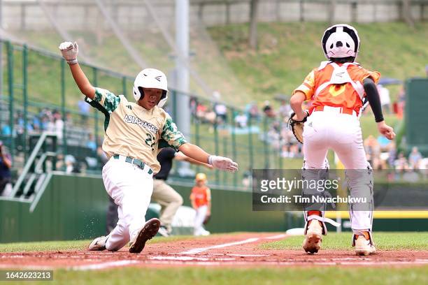 Wu Yun-Hsi of the Asia-Pacific Region team from Taipei City, Chinese Taipei scores a run during the first inning against the Southwest Region team...