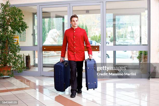 bellhop carrying luggage - bellhop stock pictures, royalty-free photos & images