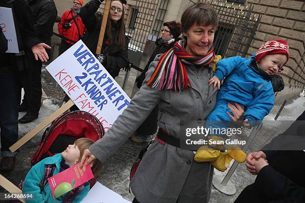 Susanna Herwig, who is lesbian and in a legal partnership with another woman, and her one and three-year-old children join protesters demanding equal...