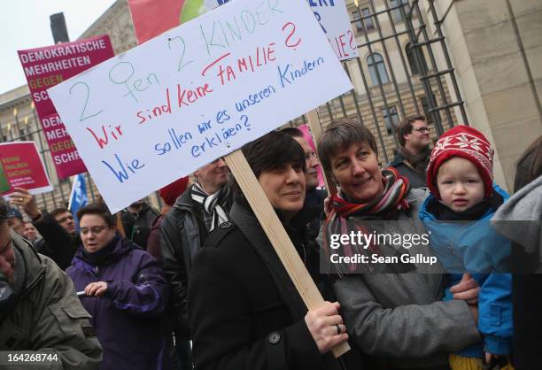 Gabriele and Susanna Herwig, who are lesbian and in a legal partnership, and one of their two children hold a sign that reads: "Two Women Two...