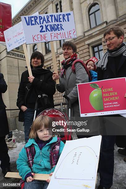 Gabriele and Susanna Herwig, who are lesbian and in a legal partnership, hold a sign that reads: "Partnered, 2 Children - Not A Family?" as they...