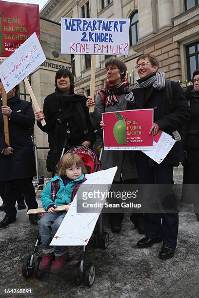 Gabriele and Susanna Herwig, who are lesbian and in a legal partnership, hold a sign that reads: "Partnered, 2 Children - Not A Family?" as they...