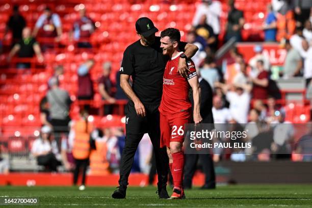 Liverpool's German manager Jurgen Klopp and Liverpool's Scottish defender Andrew Robertson celebrate at the end of the English Premier League...