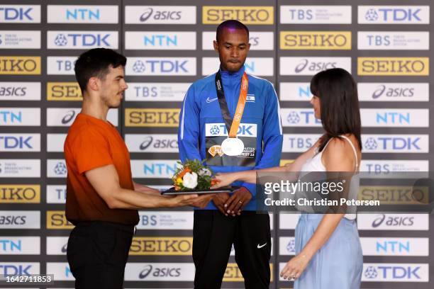Silver medalist Maru Teferi of Team Israel receives flowers from Gyorgyi Zsivoczky-Farkas, Olympic Heptathlete, during the medals ceremony for the...