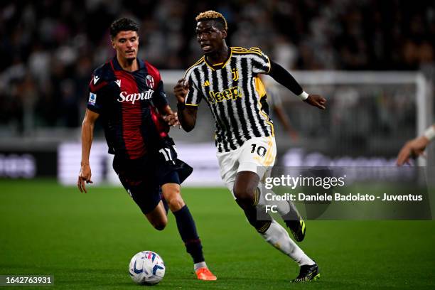 Paul Pogba of Juventus is challenged by Oussama El Azzouzi of Bologna FC during the Serie A TIM match between Juventus and Bologna FC at Allianz...