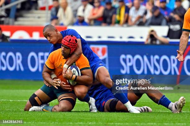 Langi Gleeson of Australia is tackled by Gael Fickou of France during the match between France and Australia at Stade de France on August 27, 2023 in...