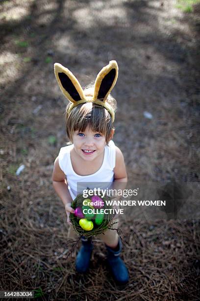 little boy with easter bunny ears and eggs in nest - easter fantasy stockfoto's en -beelden