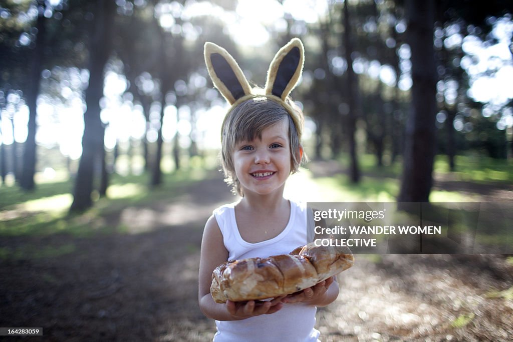 Boy in Easter bunny ears with hot cross buns