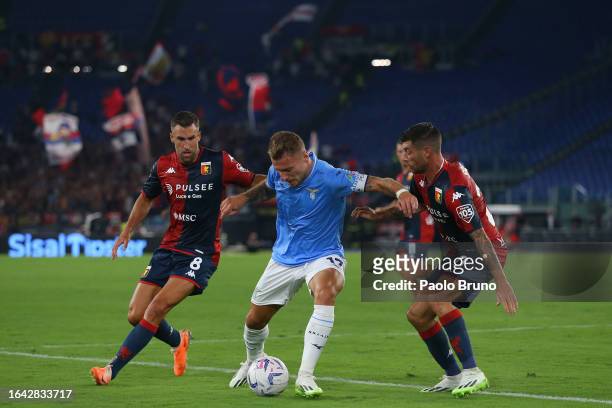 Ciro Immobile of SS Lazio competes for the ball with Kevin Strootman and Stefano Sabelli of Genoa CFC during the Serie A TIM match between SS Lazio...