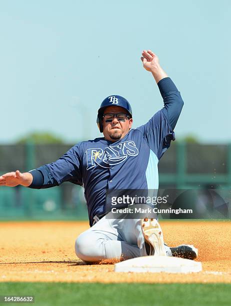 Jack Cust of the Tampa Bay Rays slides into third base during the spring training game against the Detroit Tigers at Joker Marchant Stadium on March...