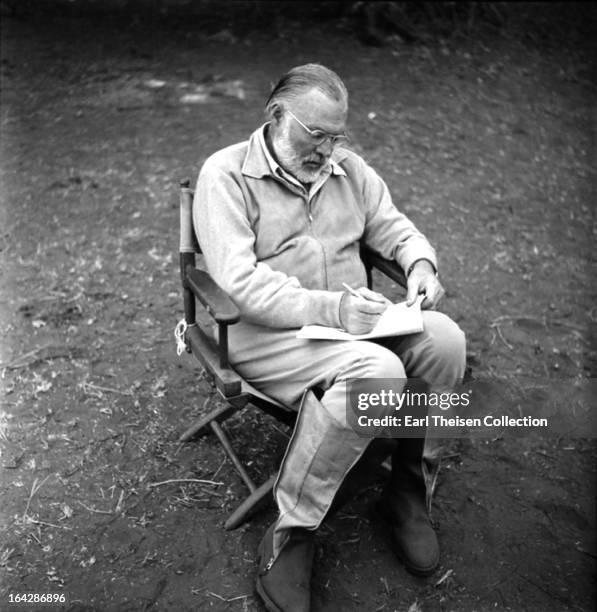 Author Ernest Hemingway writes while on a big game hunt in September 1952 in Kenya.