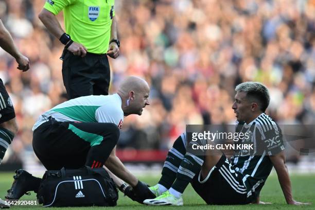 Manchester United's Argentinian defender Lisandro Martinez receives medical attention during the English Premier League football match between...